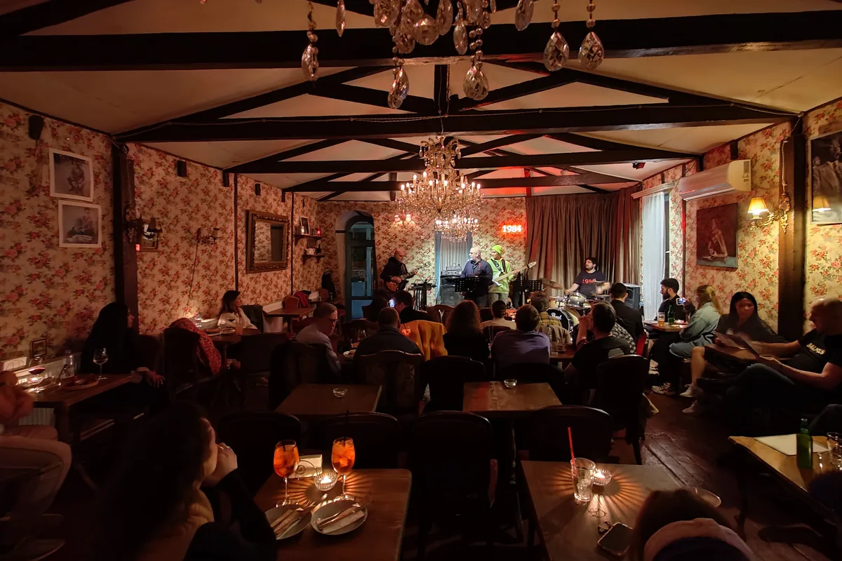 Dimly lit jazz club room with live band and floral wallpaper at 1984 Jazz Club