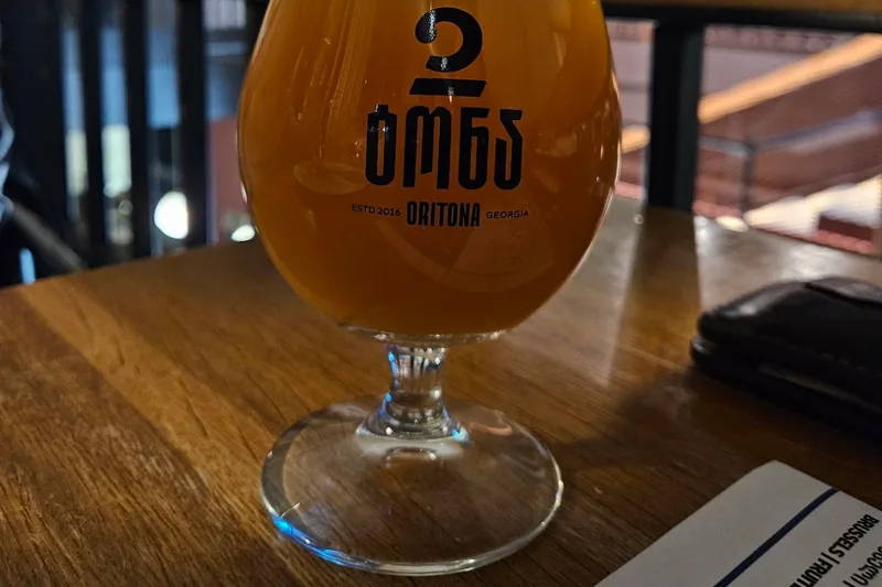 2 Tona beer in a stemmed snifter glass printed with the brewery's logo