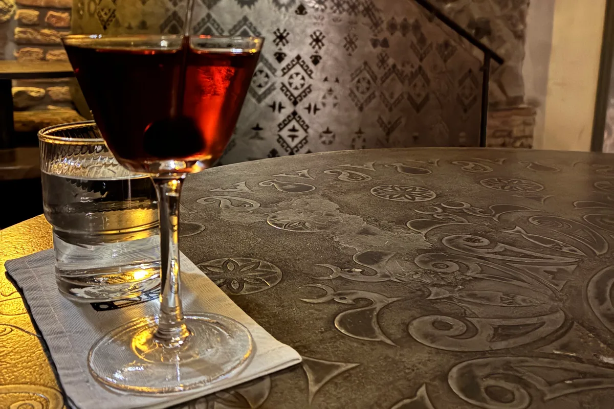 Manhattan cocktail in a coupe with a brandied cherry at 41° Art of Drinks