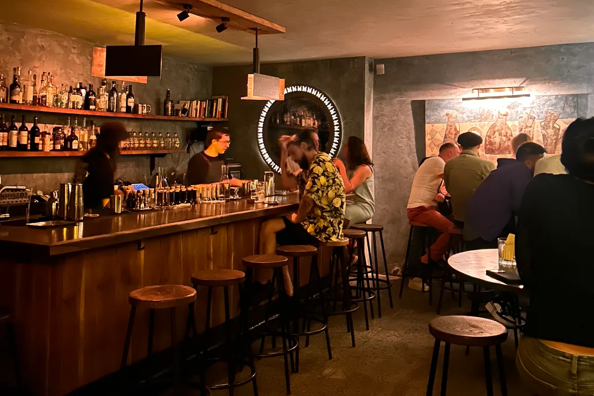 The bar counter with stools and drinkers at 41° Art of Drinks on Galaktion Tabidze Street