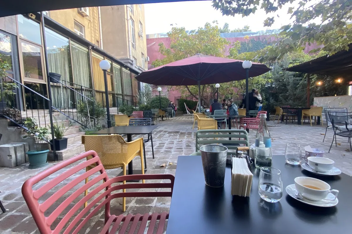 Terrace tables with red chairs at Amo Rame Bani on Aghmashenebeli Avenue, Tbilisi