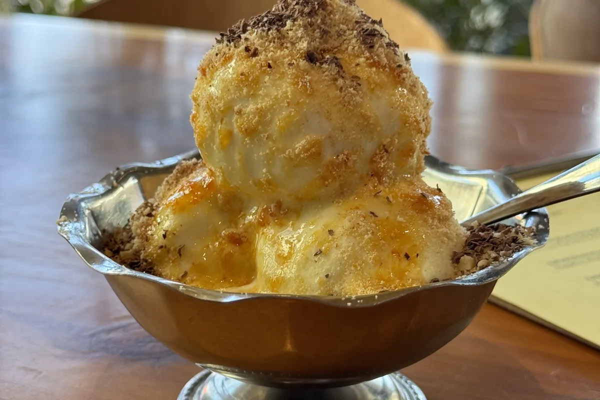 Sokhumi ice cream at Amra: scoops of plombir glazed with tangerine jam and crushed nuts in a silver dish
