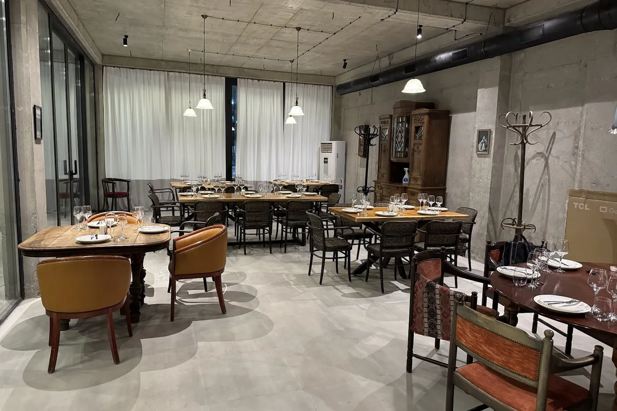 Dining room with wooden tables and leather chairs at Amra in Saburtalo