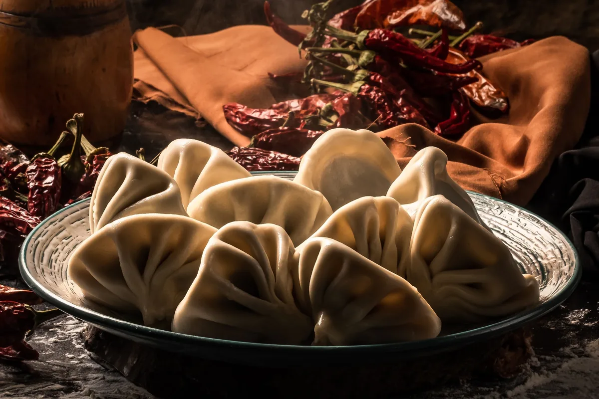 A plate of hand-pleated khinkali with dried red chillies at Asi Khinkali's Chugureti branch