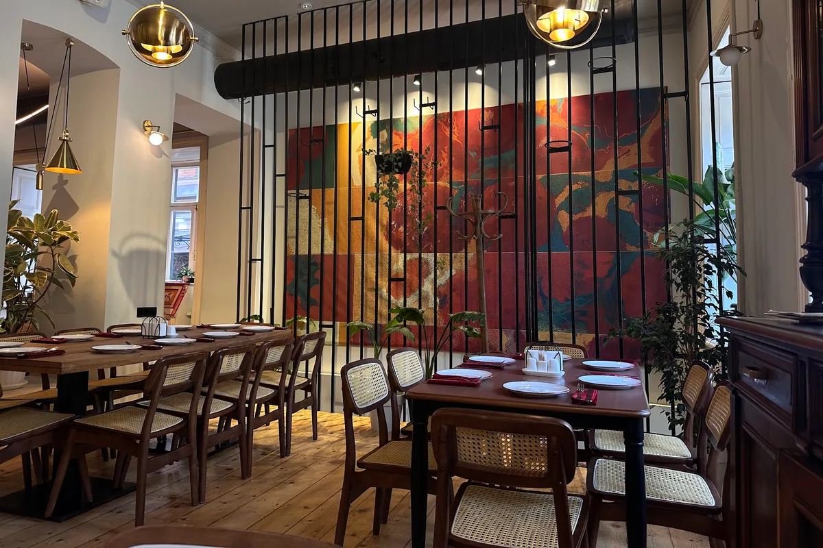 Dining room with wooden tables and cane chairs at Asi Khinkali
