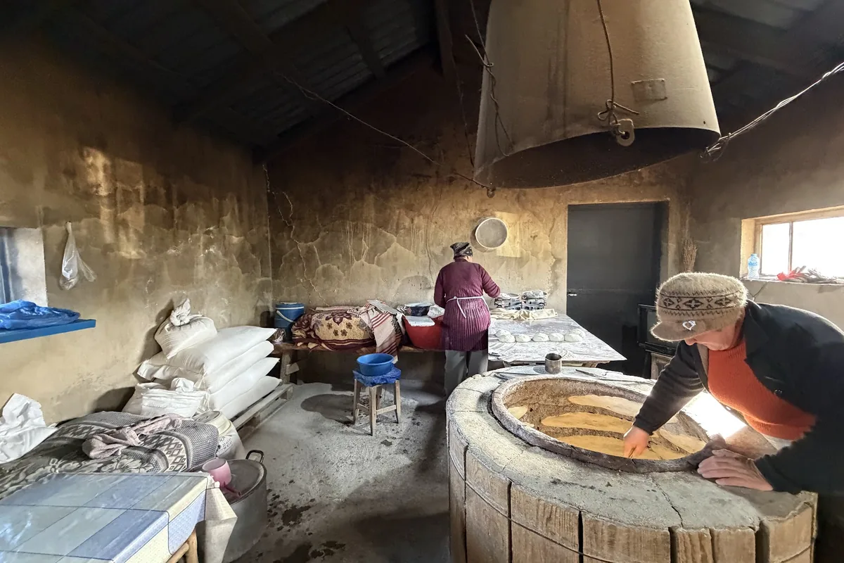 The round clay tone oven and flour sacks inside a roadside shoti bakery in Badiauri