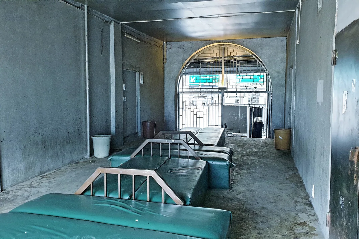 Concrete hallway with green vinyl benches at Bassiani