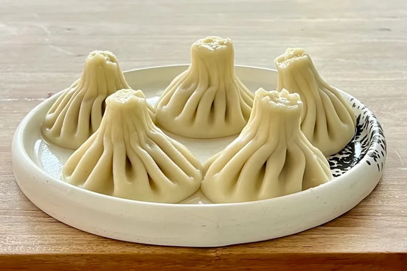 Khinkali dumplings on a ceramic plate at Bazari Orbeliani