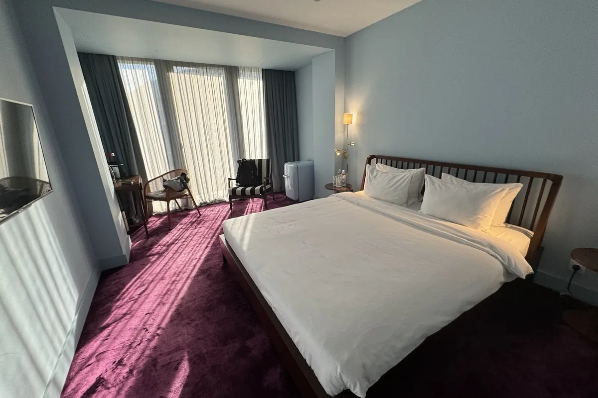 Guest room with a red carpet and tall windows at Bazzar Boutique Hotel