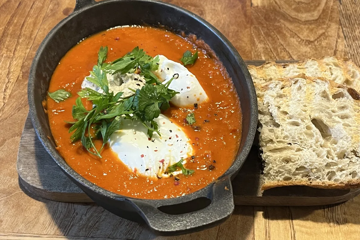 Shakshuka in a cast-iron pan with sourdough at Breakfast Is