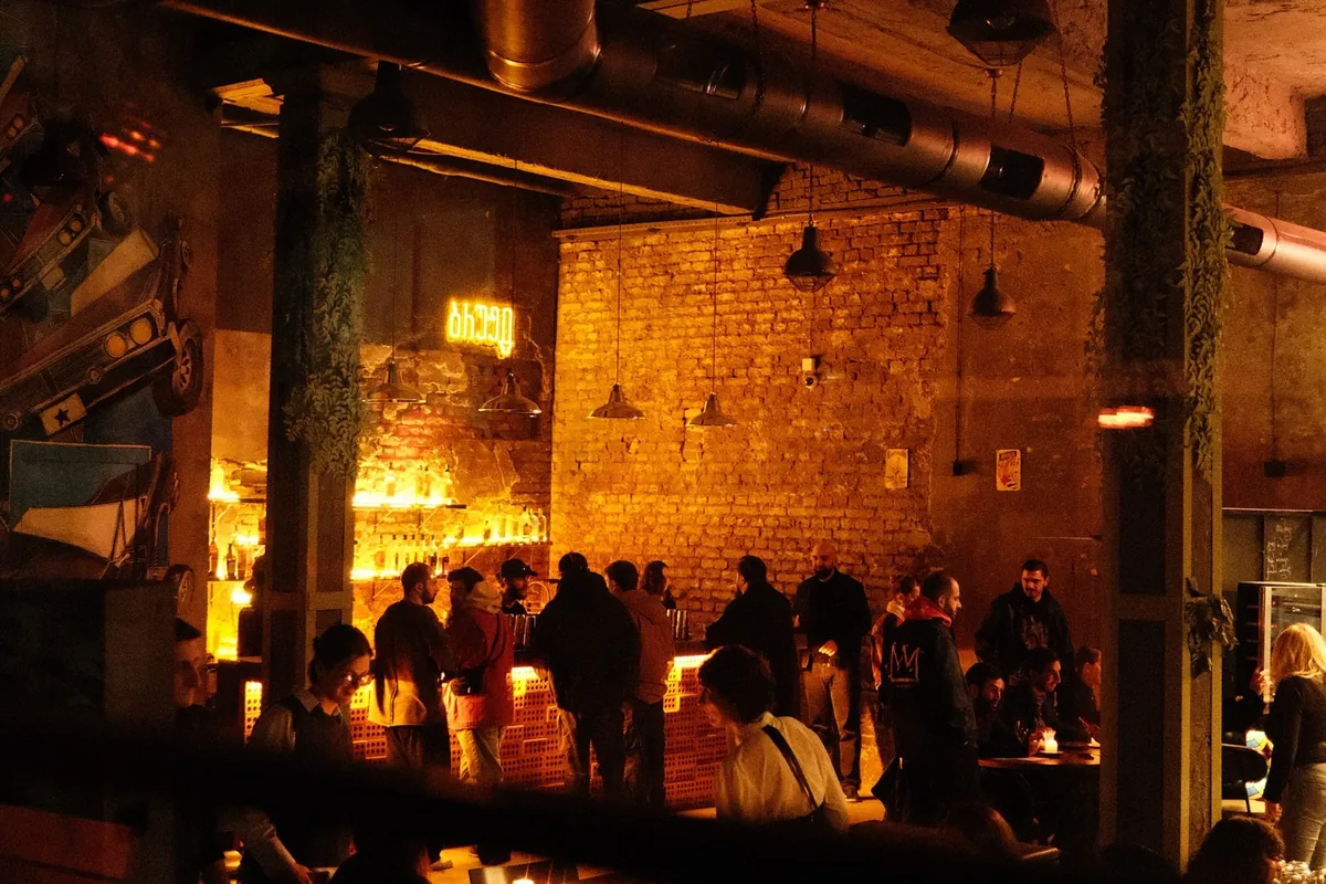 The brick-walled bar at Brouge inside Zeche, with warm pendant lights and an evening crowd