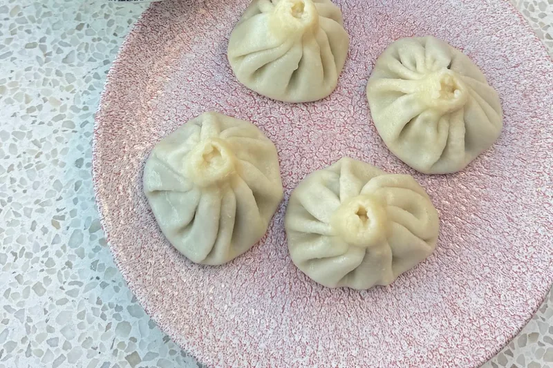 Hand-made khinkali on a pink plate at Cafe Daphna