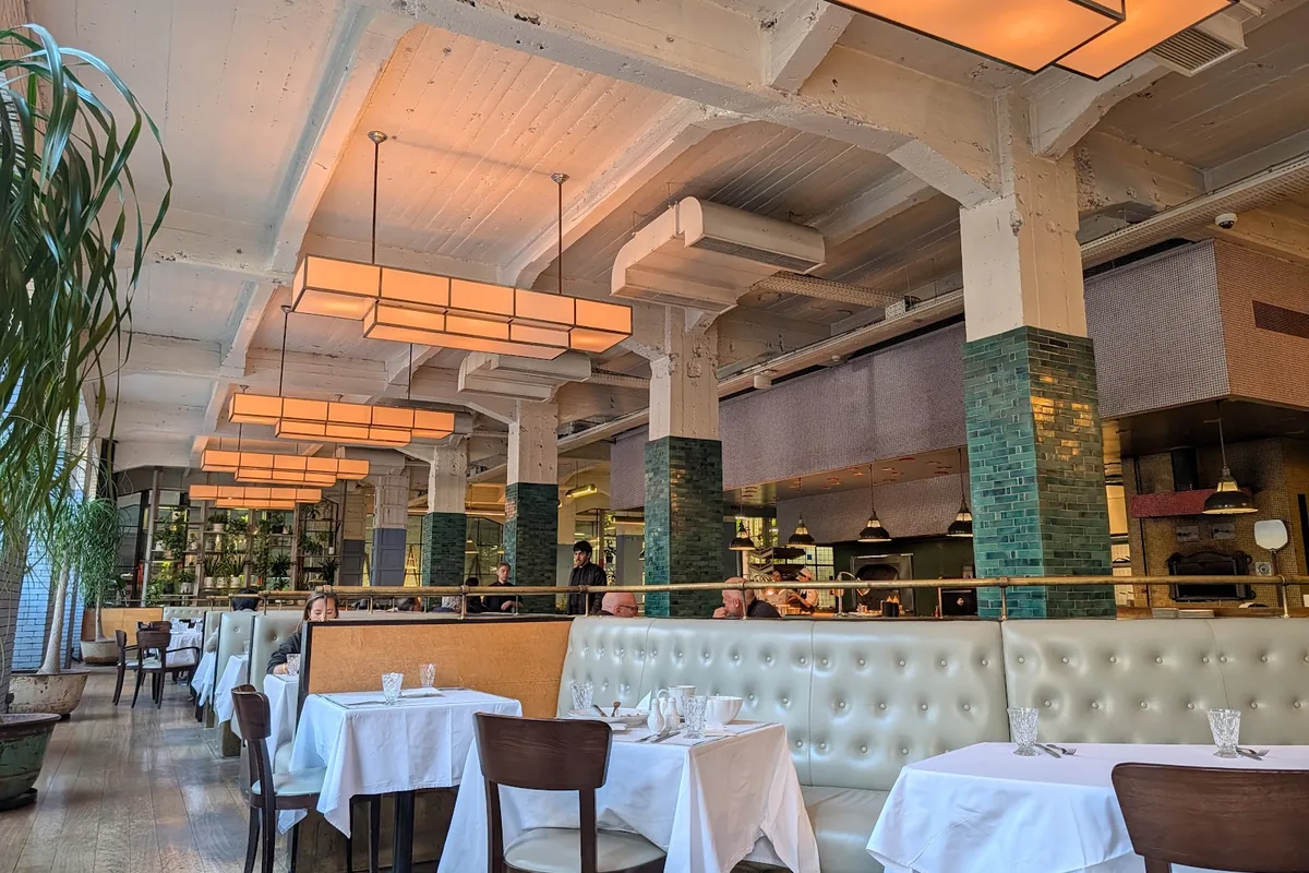 Dining room with white tablecloths in the old printing house at Cafe Stamba