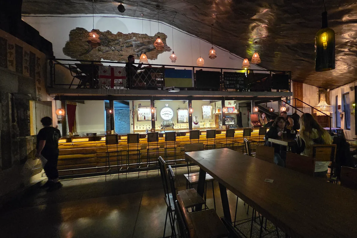 Two-level bar interior with a counter and mezzanine seating at Chacha Time