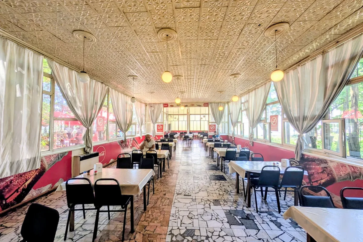 The long glassed-in dining room of the Coca-Cola Diner on Tsereteli Avenue in Didube, Tbilisi
