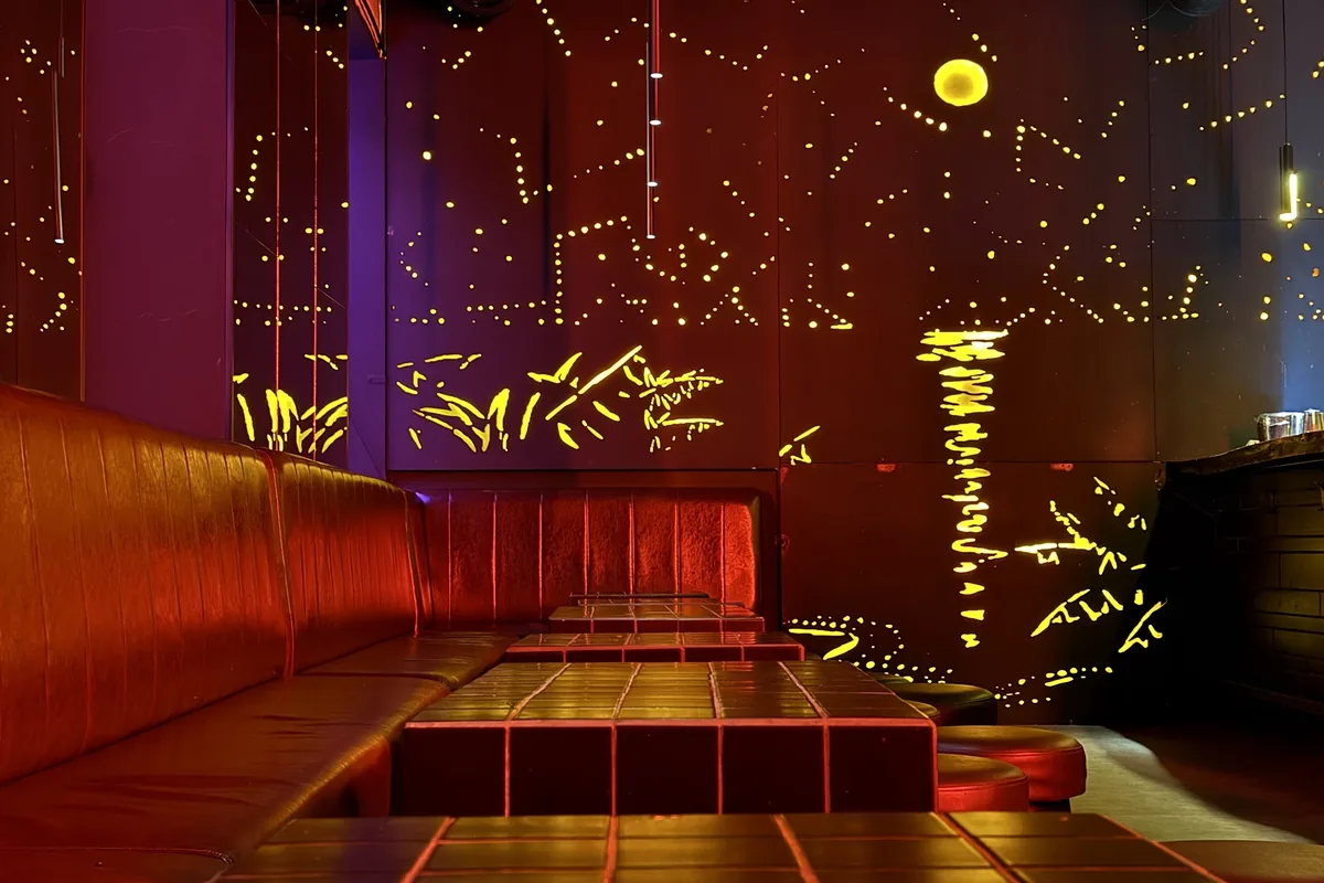 Seating booth and illuminated wall art at Cocktail Factory Tbilisi