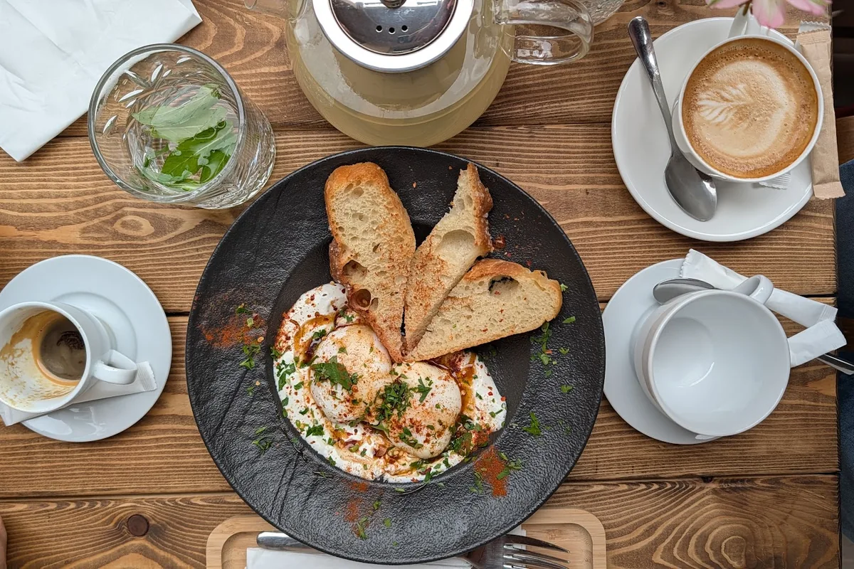 Poached eggs on yogurt with toast, a cappuccino and a pot of tea at CO:CO Coffee Collective
