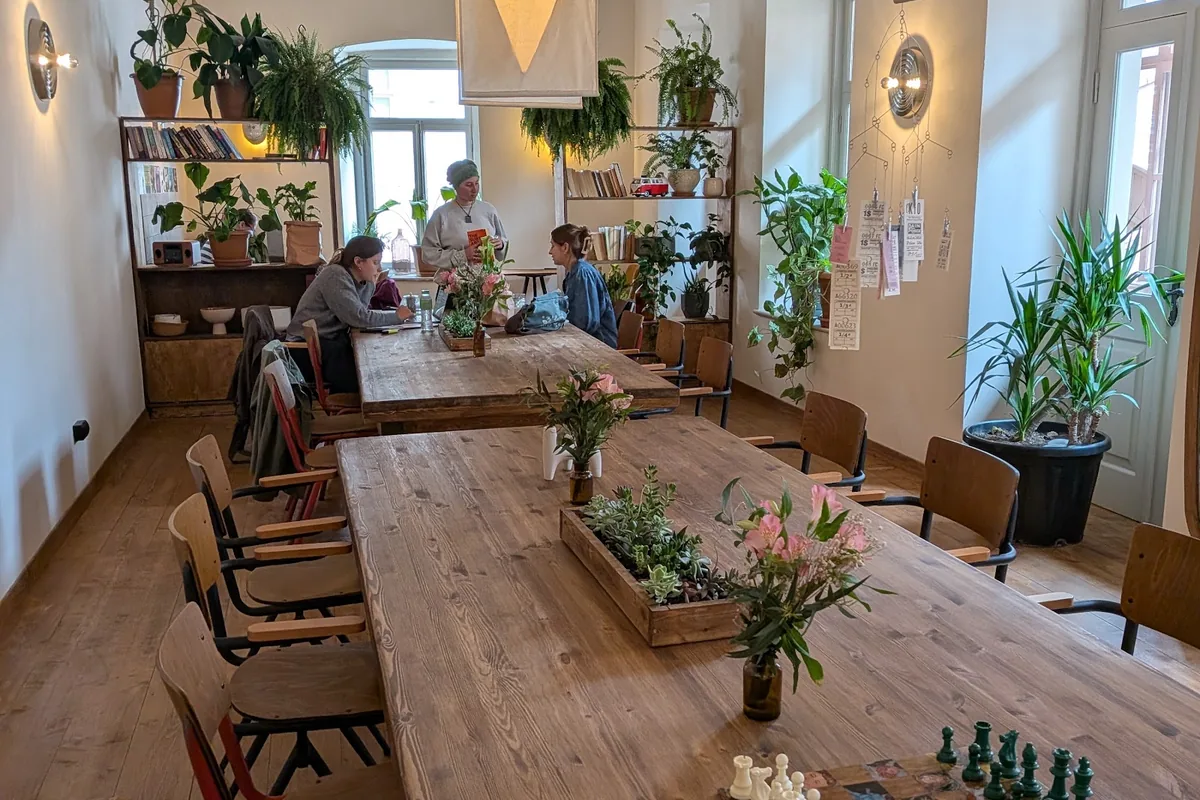 Long wooden tables under paper lamps at CO:CO Coffee Collective
