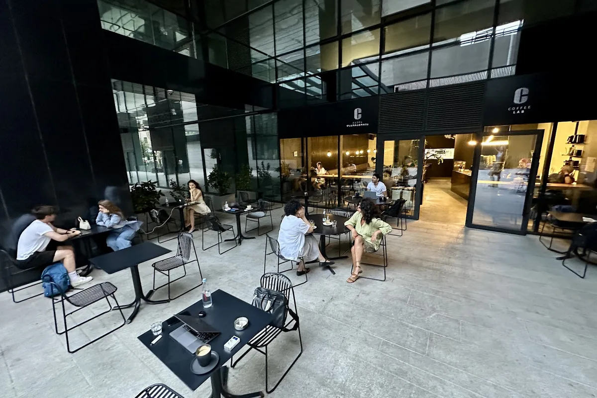 Terrace tables and glass shopfront at Coffee LAB under the Axis Towers