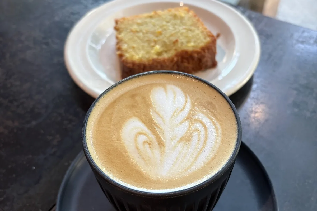 Cappuccino with latte art and a slice of cake at Coffee LAB on Kazbegi Avenue