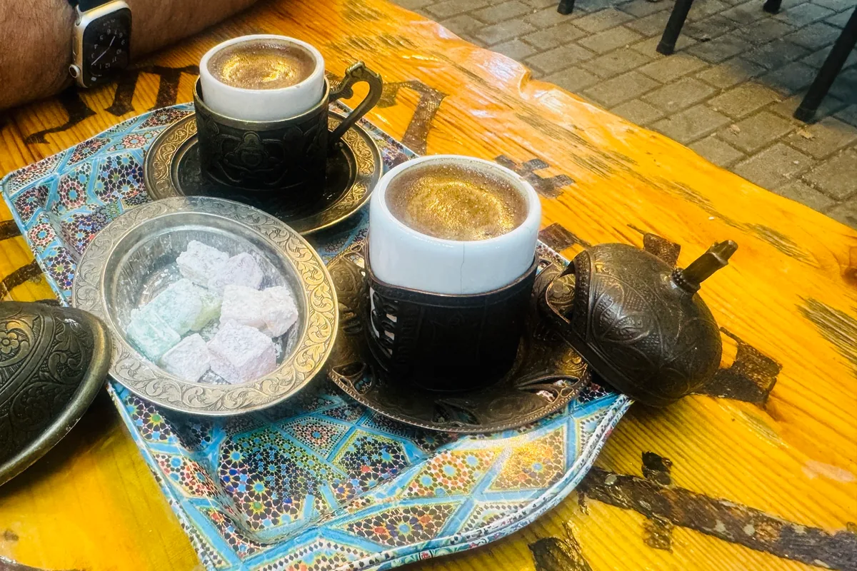 Two cups of Turkish-style coffee with the grounds in, on a tray with Turkish delight at Craft Coffee in Tbilisi