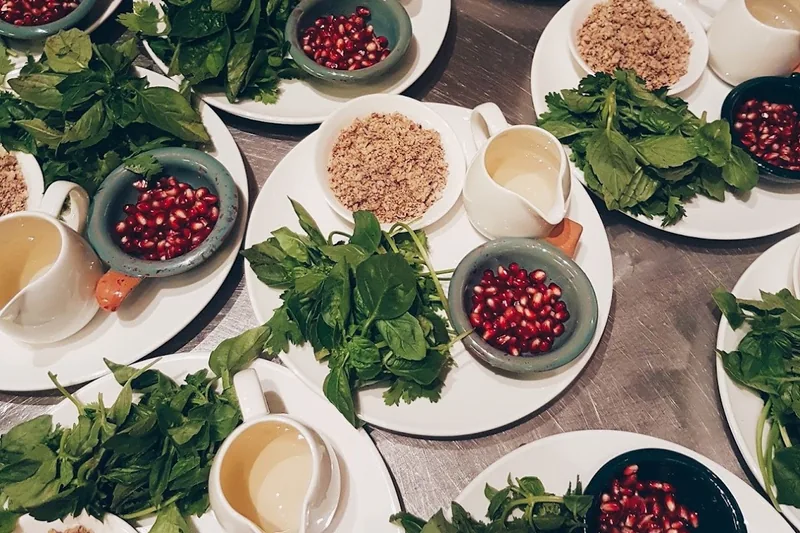 Cooking class ingredients prepped on plates with herbs, pomegranate and walnuts at Culinarium Cooking School