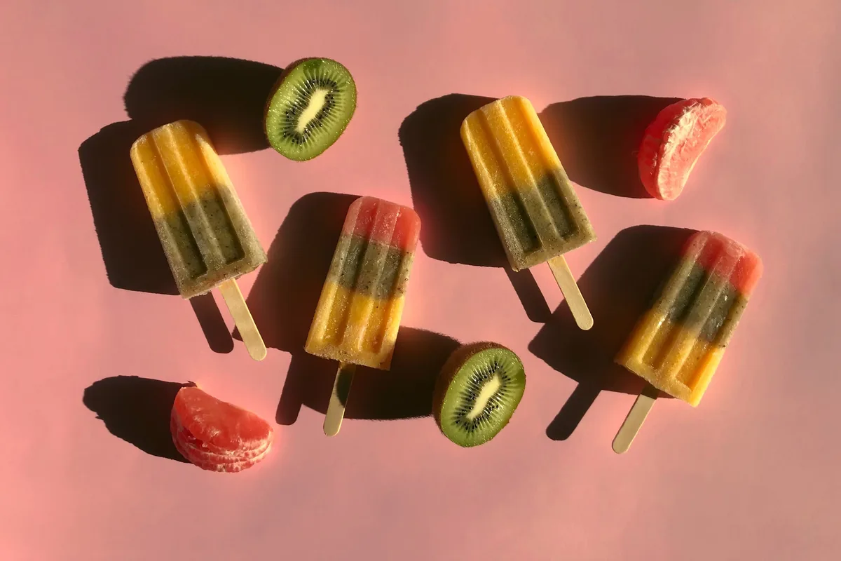 Striped fruit popsicles with kiwi and citrus slices at Cumbo Pops