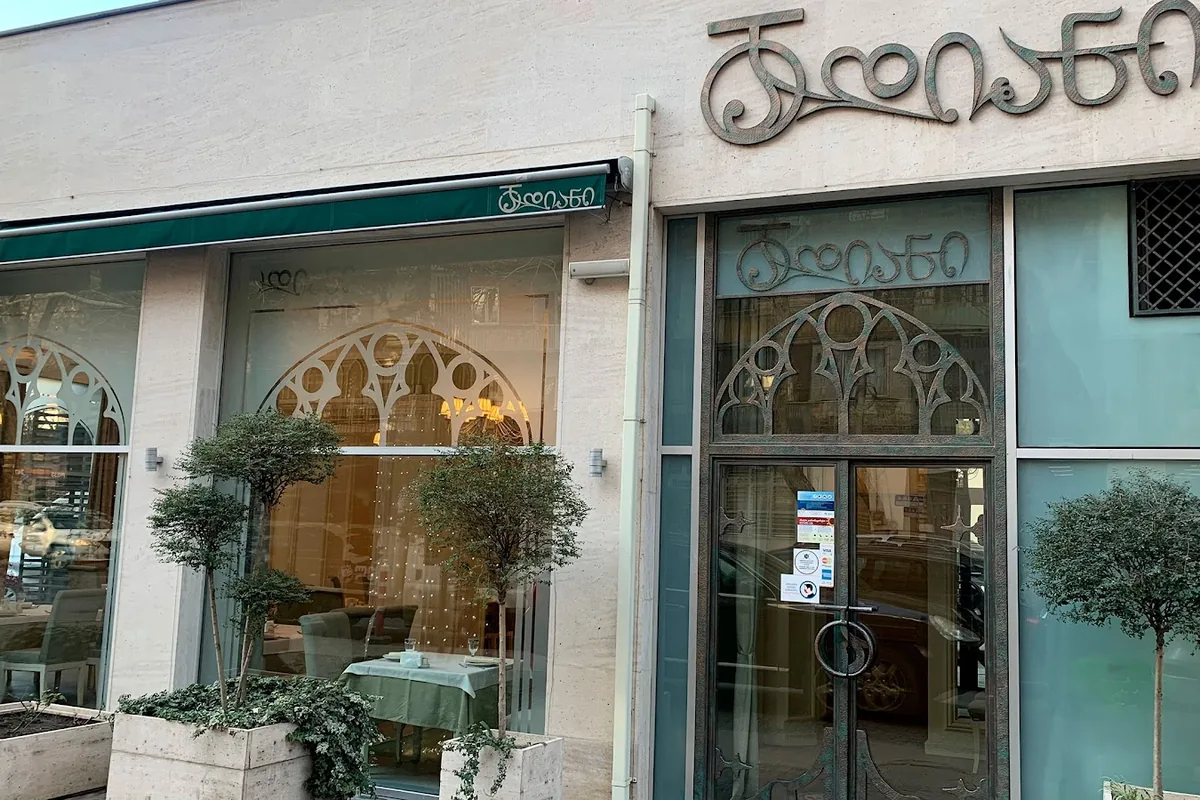 Arched windows and potted trees outside Dadiani in Saburtalo
