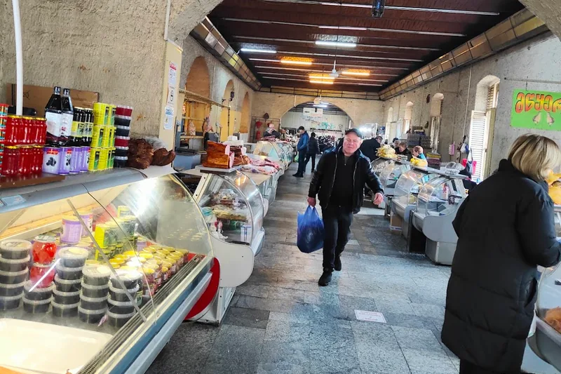 Indoor market hall with deli display cases at Dezerter Bazaar