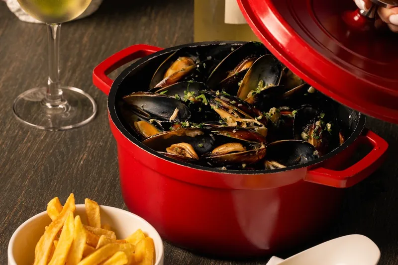 Mussels in a red cocotte with fries, a dip and white wine at Dumas