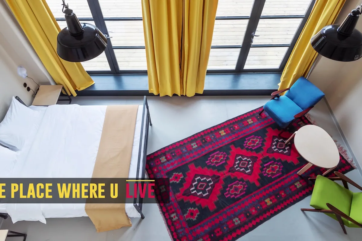 Private room with a red rug and yellow curtains at Fabrika Hostel & Suites