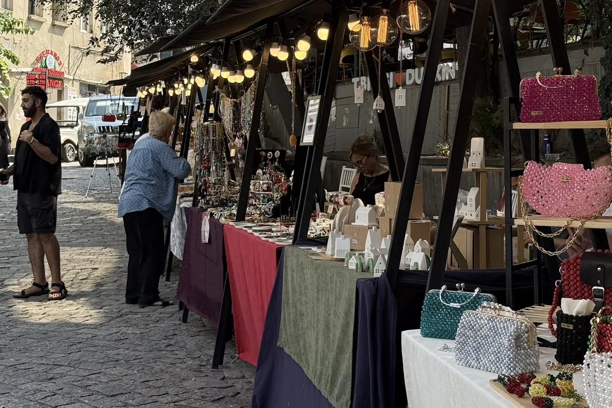 Craft stalls under string lights on the cobbled street at Flash Market on Sioni Street