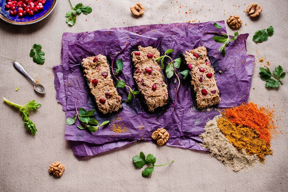 Badrijani nigvzit on purple paper garnished with pomegranate seeds at Georgian Flavors