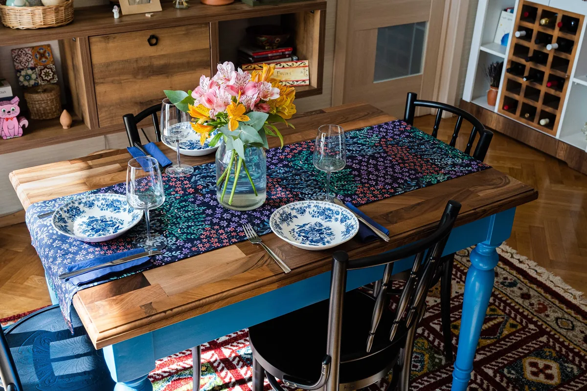 Set dining table with floral runner and vase at Georgian Flavors