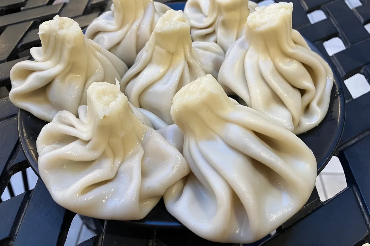 Khinkali dumplings on a black plate at Georgian House