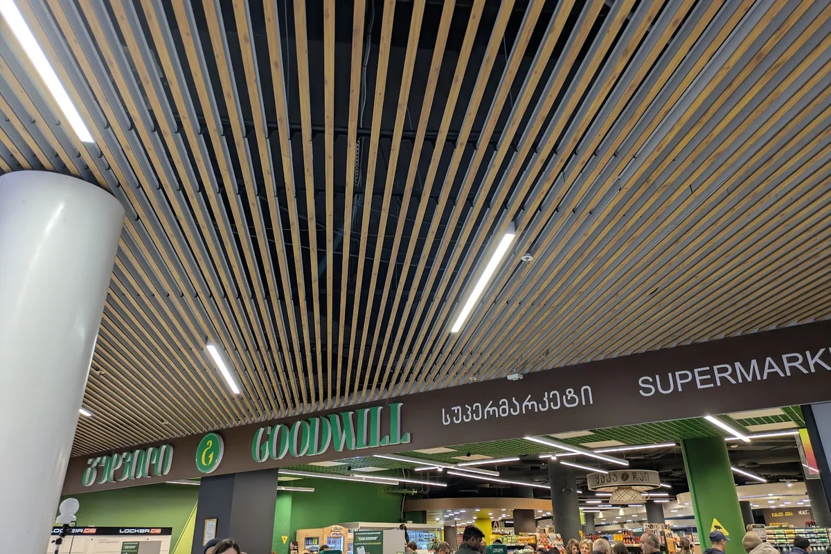 Supermarket entrance under a wood-slat ceiling in the basement of Galleria Tbilisi at Goodwill