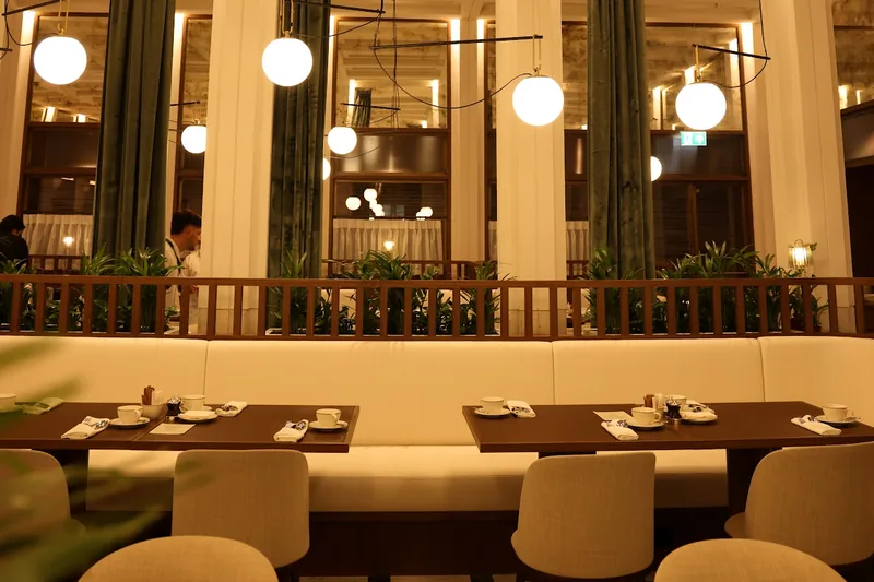 Dining room with high coffered ceilings and globe pendant lights at Grand Cafe