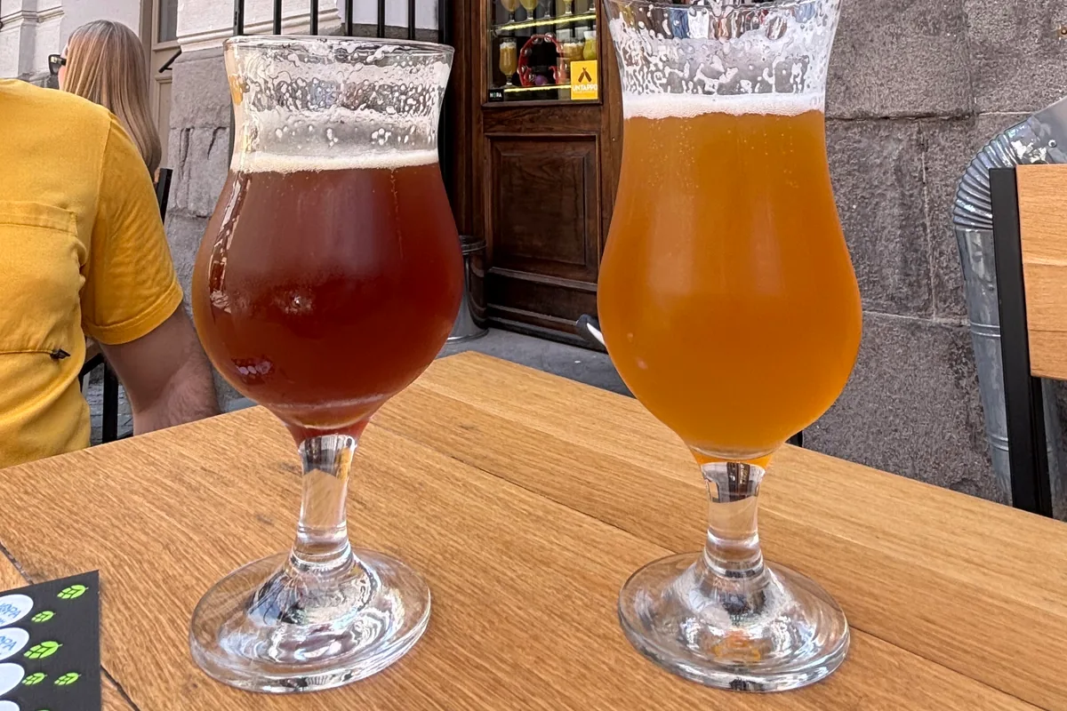 Two glasses of craft beer on an outdoor table at Hopa Taproom