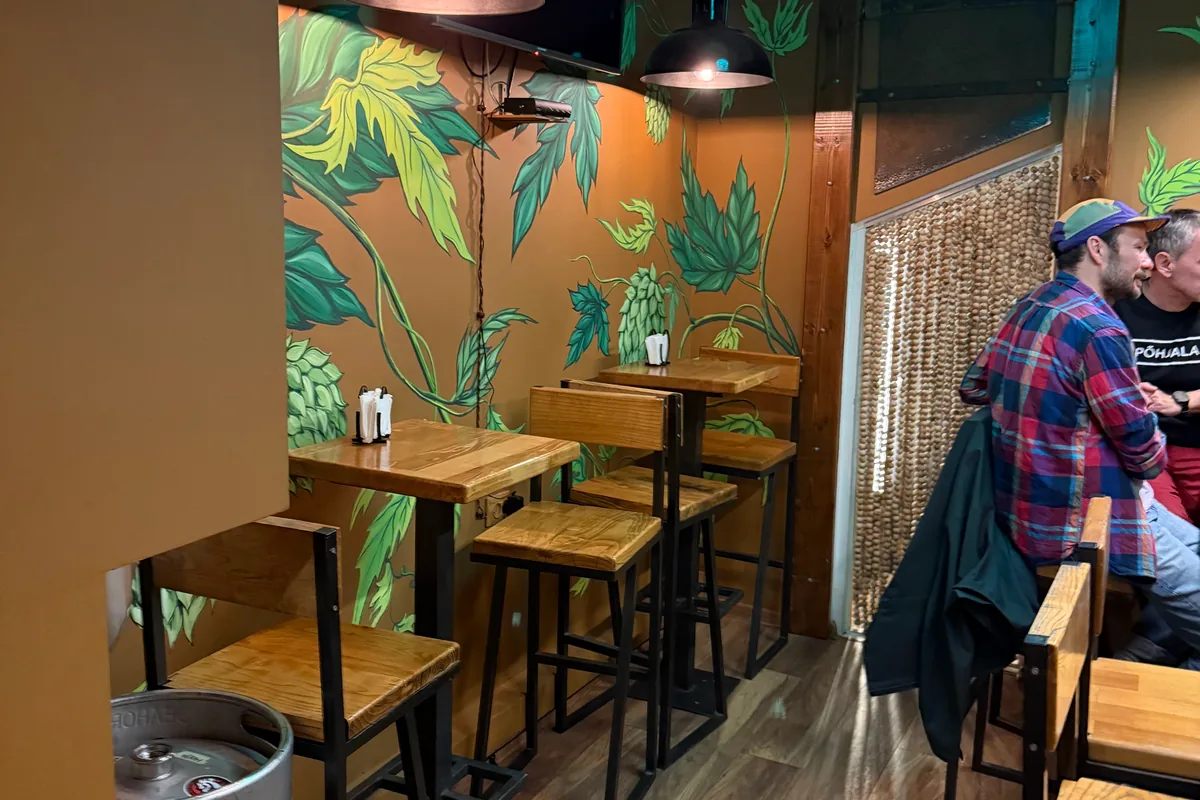 Small seating nook with painted mural and hop-shaped light at HOPA Taproom