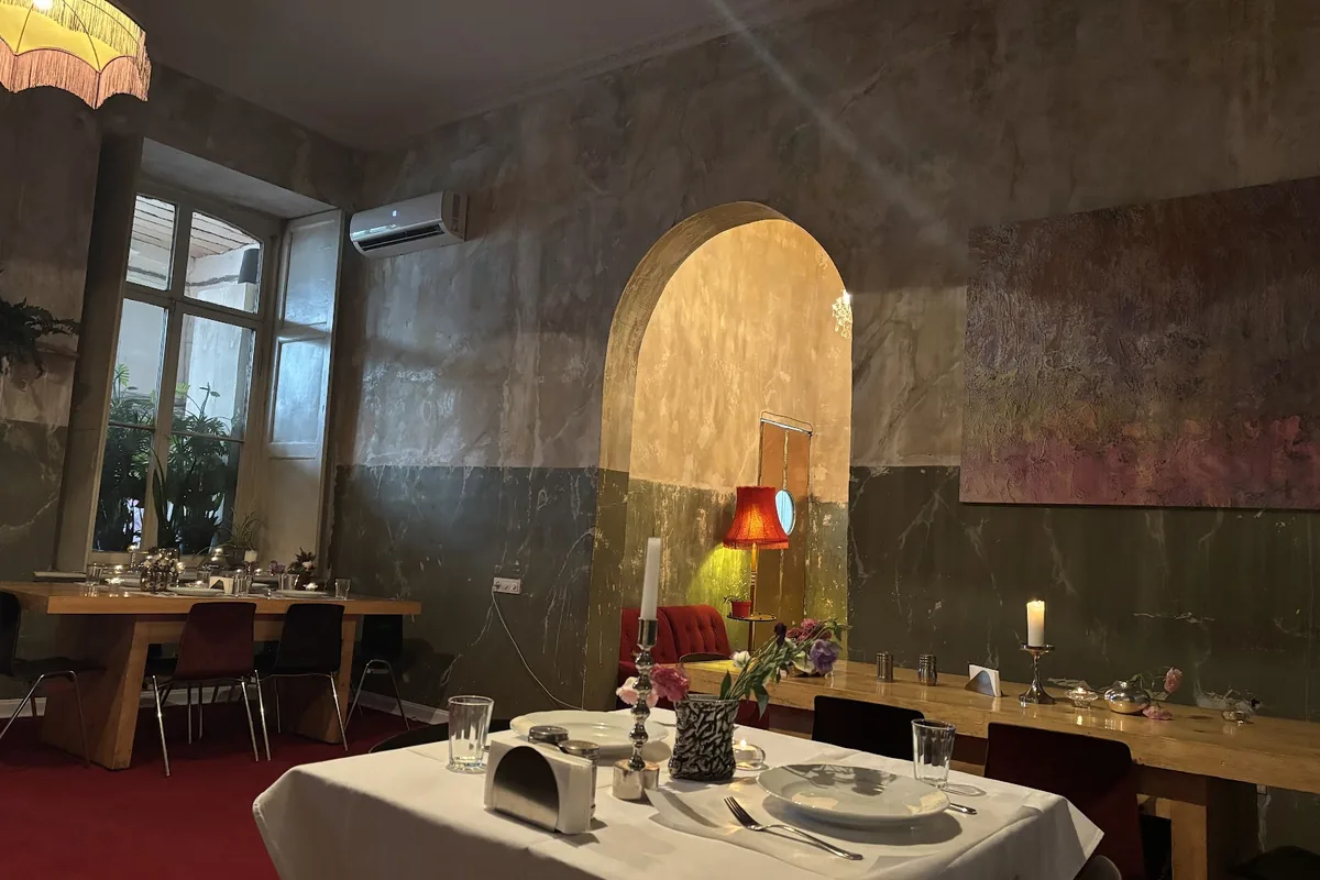 Dining room with white tablecloths and frescoed walls at Iasamani