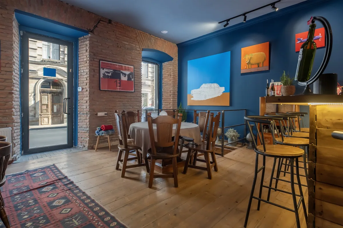 Dining room with blue walls and paintings at Kade