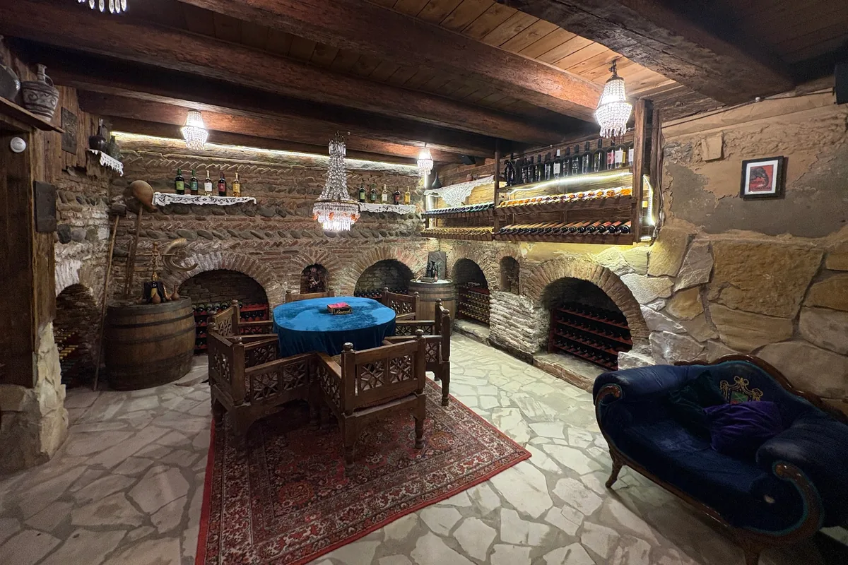 Wine cellar tasting room with brick arches and chandeliers at Karalashvili Wine Cellar