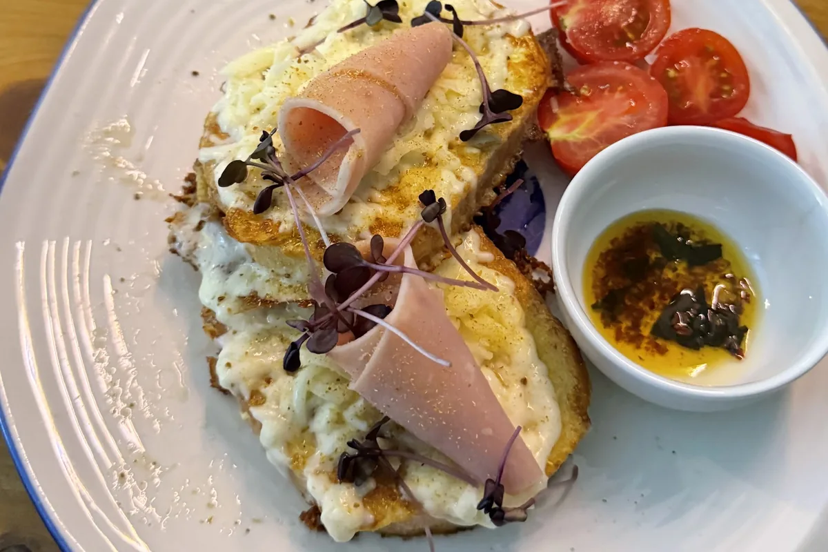 Kikliko with ham and melted cheese, egg-fried bread served with cherry tomatoes at Kikliko
