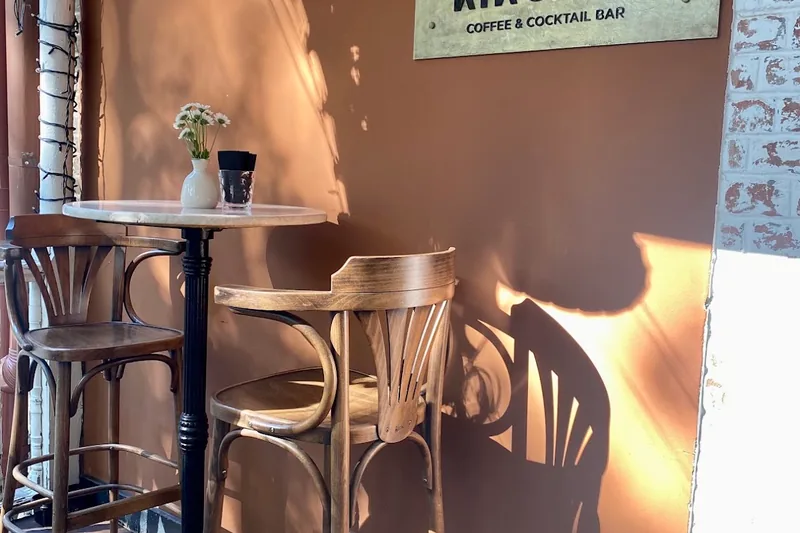 A terrace table under the coffee and cocktail bar sign at Kikodze Bar in Wine Factory N1