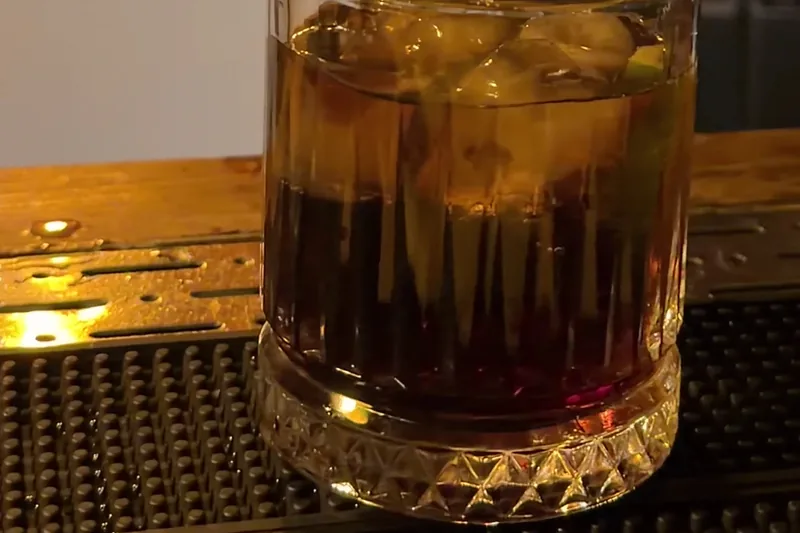 A cocktail on the rocks in a cut-glass tumbler on the bar at L'ADO by Valiko Mansion