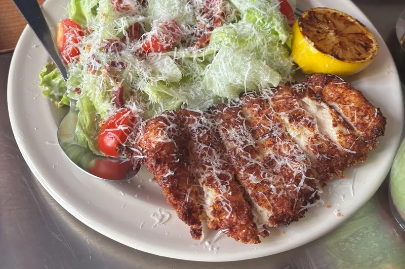 Chicken schnitzel with caesar salad and a charred lemon at Londa