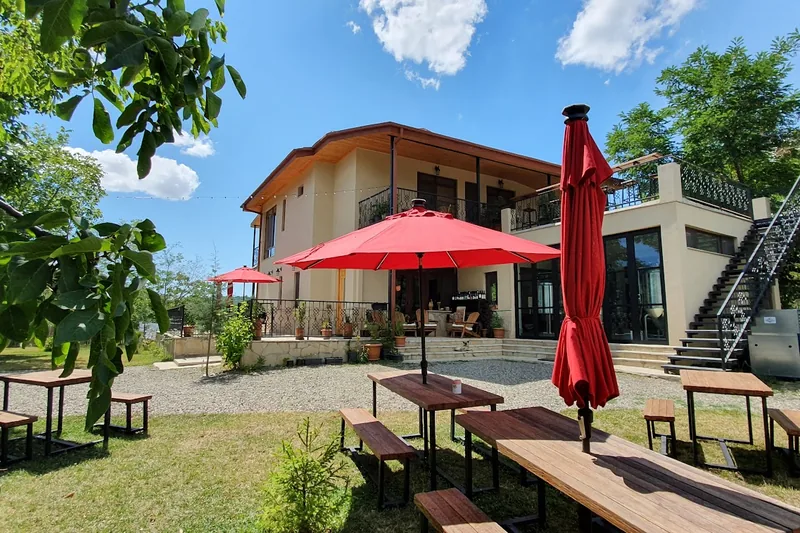 The two-storey inn with red umbrellas over the garden tables at Lost Ridge Inn outside Sighnaghi