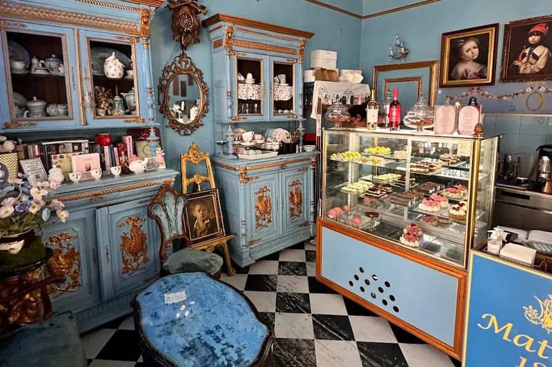 Tiffany-blue parlor with gilded cabinets and a pastry case at Matasse 1822 in Old Tbilisi