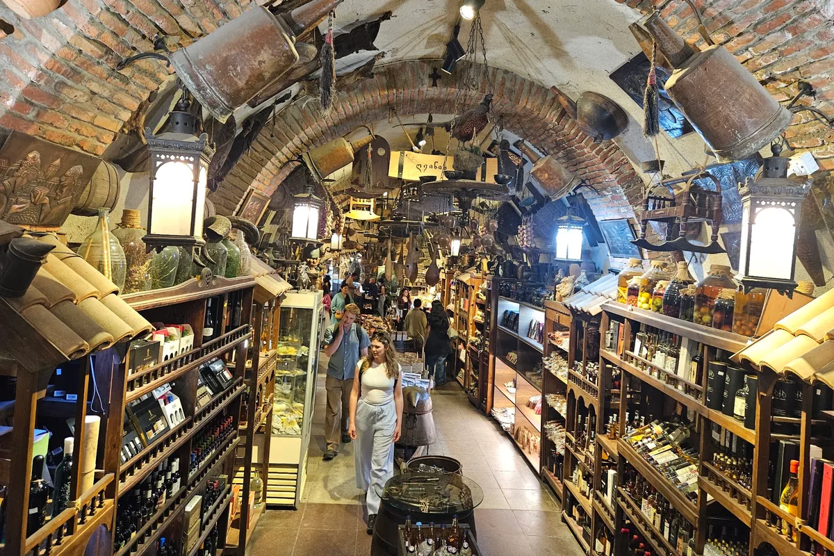 The brick-vaulted tunnel of the Meidan bazaar, lined with shelves of wine, jars of preserves and souvenirs