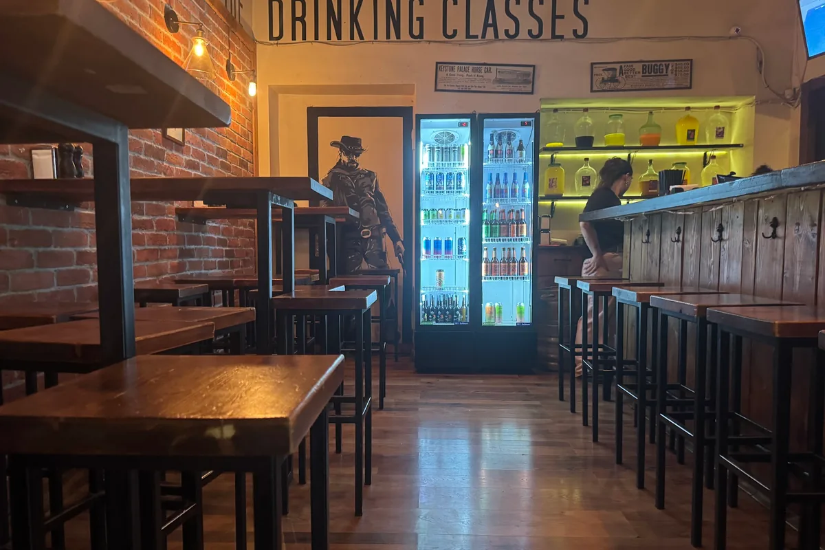 Brick and wood bar interior with high tables and stools at Number 8 - Craft Beer Club